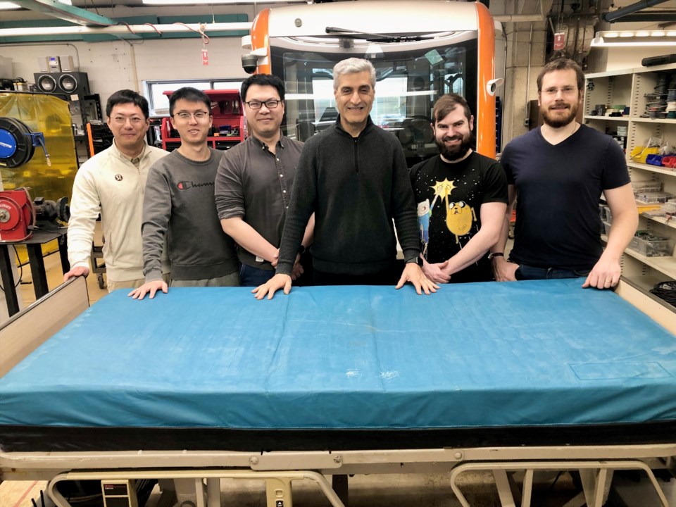 Researchers (left to right): post-doctoral fellow Dr. Keqi Shu, PhD students Minghao Ning and Frank Yang, Professor Amir Khajepour, and technicians Mike Duthie and Jeff Graansma pose with a robotic bed they are using to develop an autonomous mobility system for hospitalsImage supplied by University of Waterloo